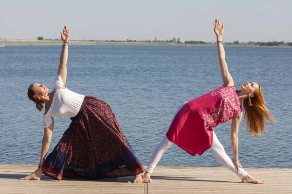 Zwei reife Frauen halten sich fit, indem sie im Sommer Yoga machen — Stockfoto