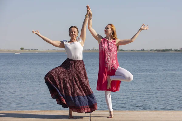 Zwei reife Frauen halten sich fit, indem sie im Sommer Yoga machen — Stockfoto