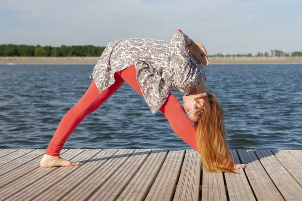 Bild einer hübschen Frau beim Yoga am See — Stockfoto