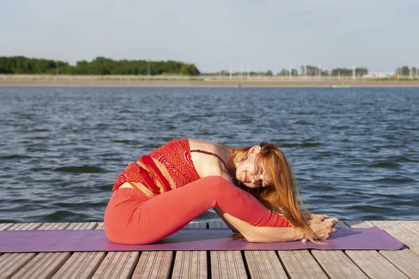 Junge Frau praktiziert Yoga in der Natur. — Stockfoto