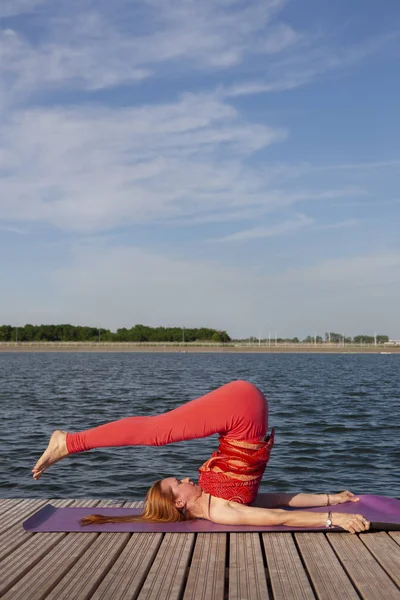 Junge Frau praktiziert Yoga in der Natur. — Stockfoto