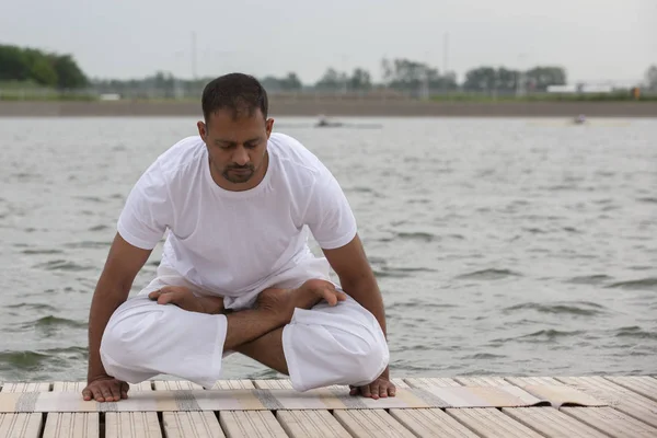 Młody człowiek robi jogę i medytuje w wojownika stwarzają na plaży — Zdjęcie stockowe