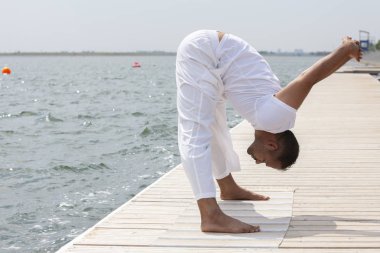 Adam pratik yoga gün batımında sahilde
