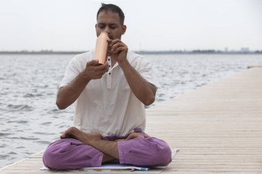 Doğada ahşap zeminde yoga yapan adam. Tatlı su koruma konsepti.