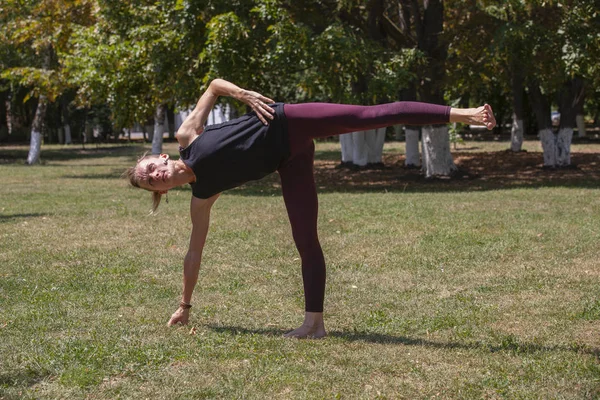 Giovane donna che fa yoga nel parco del mattino — Foto Stock