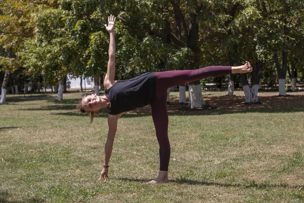 Giovane donna che fa yoga nel parco del mattino — Foto Stock