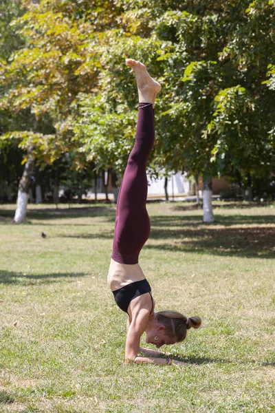 Donna su un tappetino yoga per rilassarsi nel parco . — Foto Stock