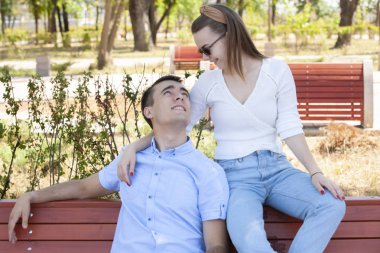 Parktaki bankta oturan genç ve güzel bir çift