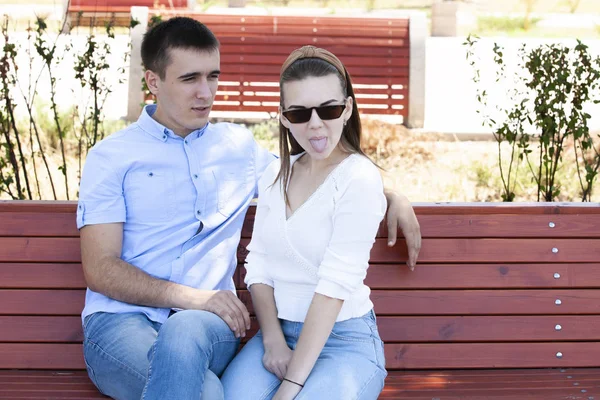 Feliz jovem casal apaixonado sentado em um banco de parque — Fotografia de Stock