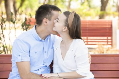 Genç çift parkta bankta oturuyor..