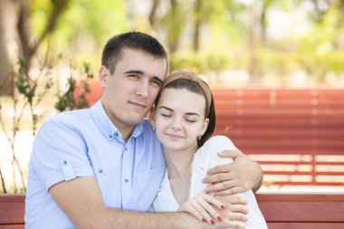 Genç çift parkta bankta oturuyor..