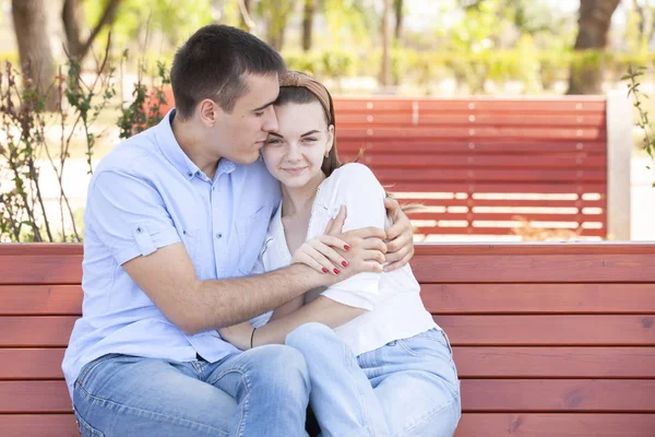 Jong stel zittend op bank in park. — Stockfoto