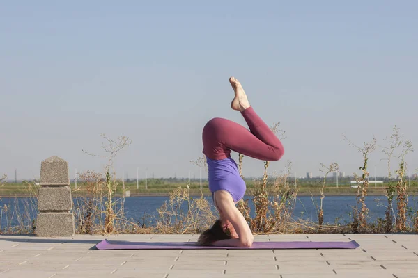 Esercizio di yoga donna che fa yoga posa meditazione nel parco pubblico sport concetto sano . — Foto Stock