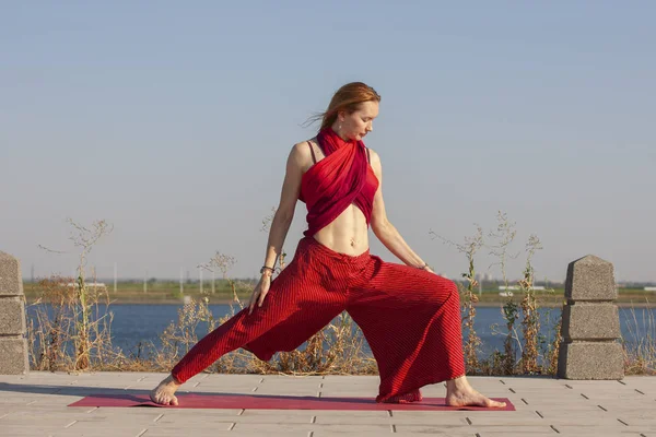 Pretty woman doing yoga exercises in the park — Stock Photo, Image