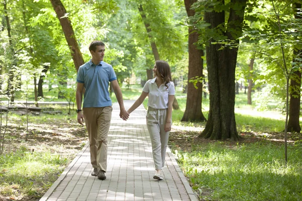 Пара прогулок рука об руку в парке - романтическое свидание на открытом воздухе — стоковое фото
