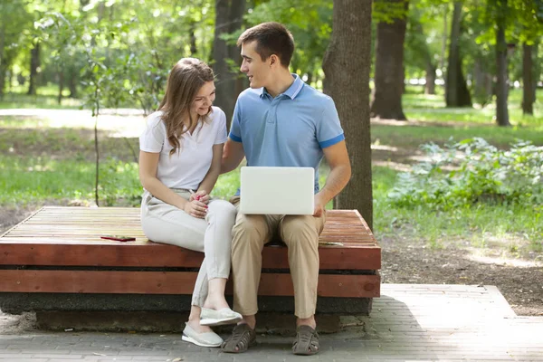 Un chico y una chica están leyendo un libro en un parque de la ciudad en un caluroso día de verano. . — Foto de Stock