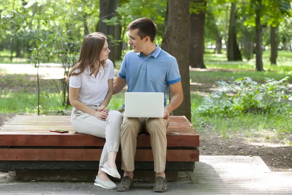 Un chico y una chica están leyendo un libro en un parque de la ciudad en un caluroso día de verano. . —  Fotos de Stock