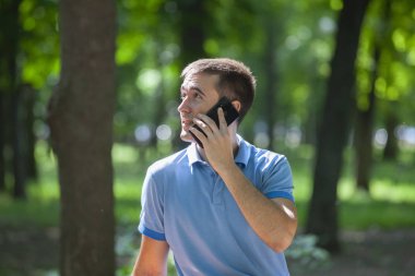 parkta bankta tek başına oturan çekici yetişkin adam