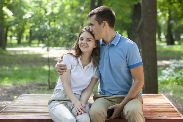 Parktaki bankta oturan genç ve güzel bir çift — Stok fotoğraf