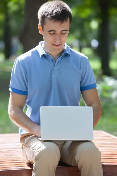 年轻人与笔记本电脑坐在木凳上 — 图库照片