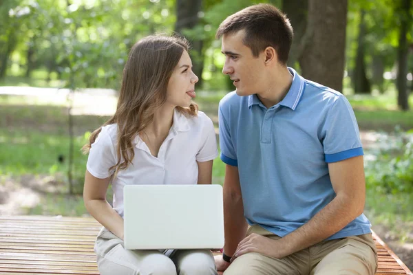 Un chico y una chica están leyendo un libro en un parque de la ciudad en un caluroso día de verano. . — Foto de Stock