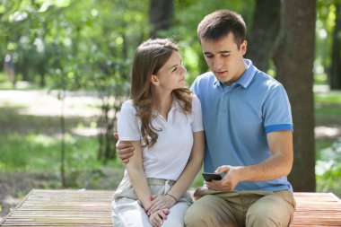 Parktaki bankta oturan genç ve güzel bir çift