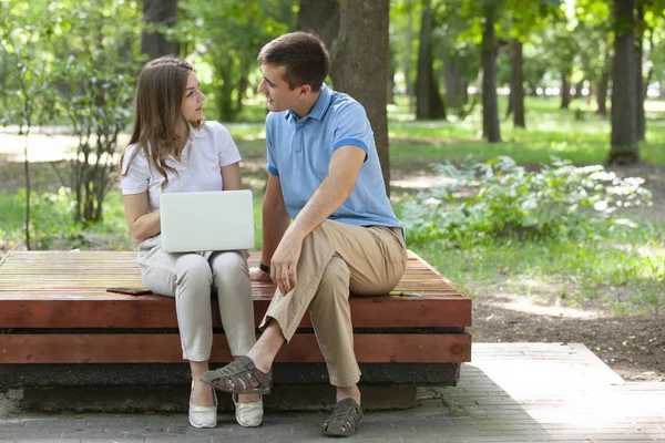 Ein Kerl und ein Mädchen lesen an einem heißen Sommertag in einem Stadtpark ein Buch. — Stockfoto