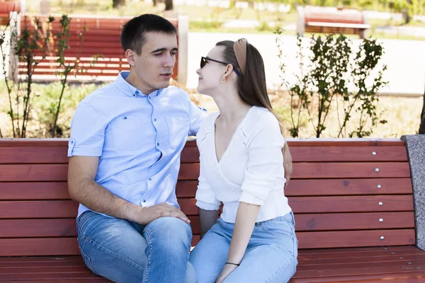 Gelukkige jonge paar verliefd zittend op een bankje — Stockfoto