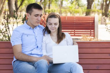 bir dizüstü bilgisayar açık havada kullanarak ve mutlu görünümlü Çift.