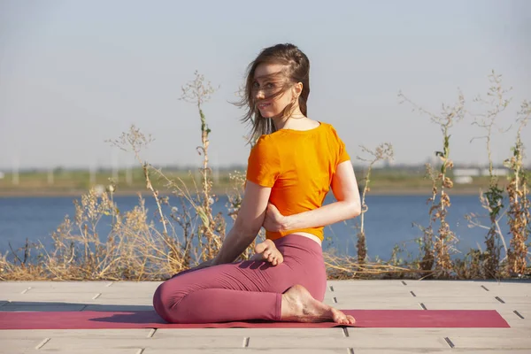 Йога на открытом воздухе. Счастливая женщина занимается йогой, медитирует в парке. Медитация йоги в природе. Концепция здорового образа жизни и отдыха . — стоковое фото
