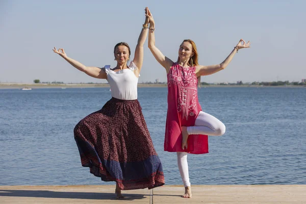 Zwei reife Frauen halten sich fit, indem sie im Sommer Yoga machen — Stockfoto