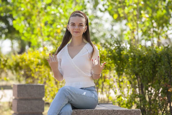 Joven hermosa mujer sentado en banco en parque . — Foto de Stock