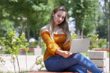 Bayan Park yeşil çim üstünde laptop