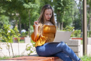 Bayan Park yeşil çim üstünde laptop