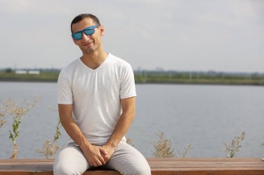 Gülen sakallı genç adam başparmak yukarı gösteren. Neşeli yakışıklı genç adam açık işaret.