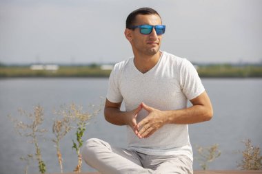 Gülen sakallı genç adam başparmak yukarı gösteren. Neşeli yakışıklı genç adam açık işaret.