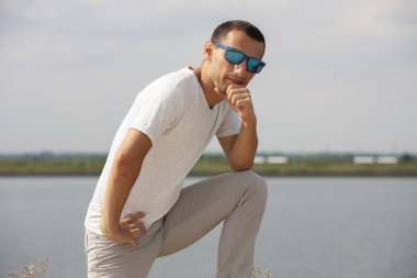 Gülen sakallı genç adam başparmak yukarı gösteren. Neşeli yakışıklı genç adam açık işaret.