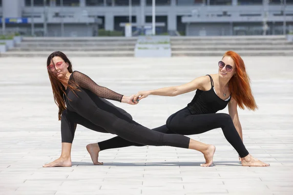 Two mature women keeping fit by doing yoga in the summer