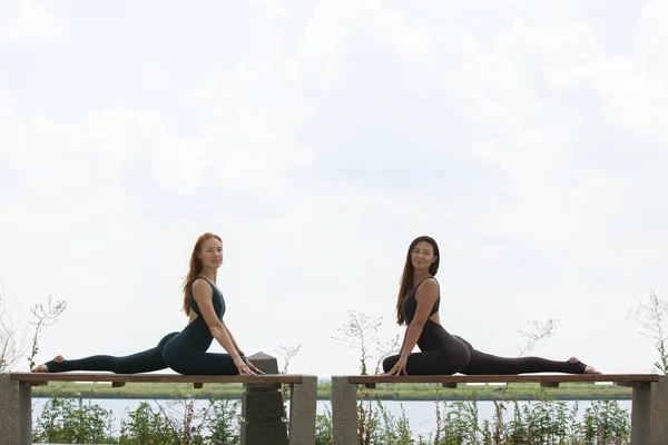 Zwei Frauen beim Yoga im Freien. Yogalehrer zeigt Posen — Stockfoto