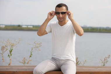 Güneşli bir günde kameraya bakan mutlu hipster yakın