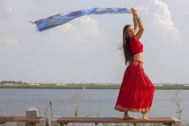 Fitness kız sabah parkta germe ısınma egzersiz yapıyor. Yoga yapan genç bir kadın. Kadın fitness modeli açık çalışma. Sağlıklı yaşam tarzı kavramı. Kırmızı saree.
