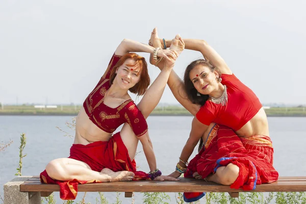 Bir çift kız yoga yada. Geleneksel saree kadınlar.