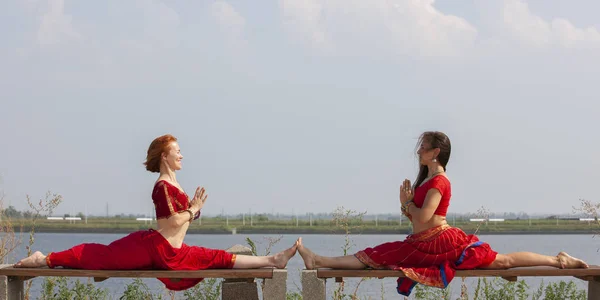 Par flickor praktisera yoga. Kvinnor i en traditionell Saree. — Stockfoto