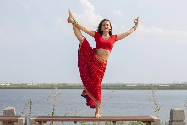 Fitness Girl gör stretching WarmUp övning på Morning Park. Ung kvinna som tränar yoga. Kvinnlig fitness modell arbetar utomhus. Begreppet hälsosam livsstil. Röd Saree. — Stockfoto