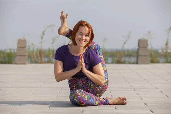 Schöne Frau macht Yoga-Übungen im Park. — Stockfoto