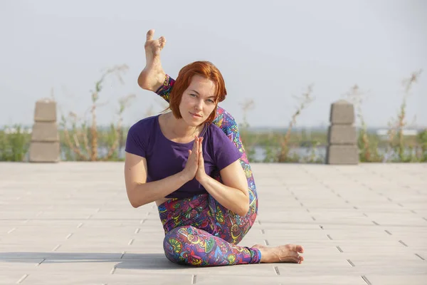 Mooie vrouw doen yoga oefeningen in het park. — Stockfoto