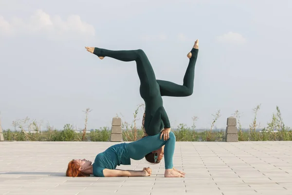 Fitness, Stretching-Praxis, Gruppe von zwei attraktiven Frauen, die Yoga machen. Wellness-Konzept. — Stockfoto