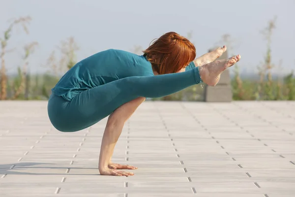 Young beautiful girl athlete practices yoga on a sunny summer day at the stadium in the fresh air. — Stock Photo, Image