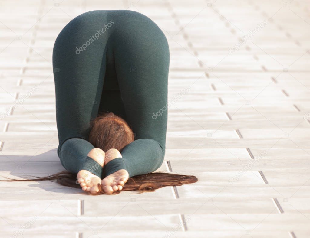 Woman doing yoga near river, enjoying good weather and positive energy in nature.