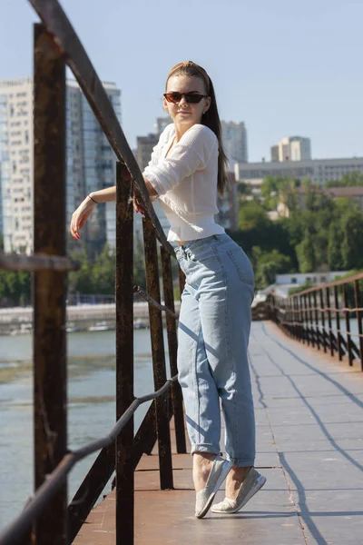 Jonge vrouw op de pier aan de rivier. — Stockfoto